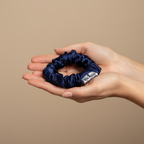 Тъмно синьо копринено скрънче в дланите