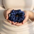 Тъмно синьо копринено скрънче в дланите